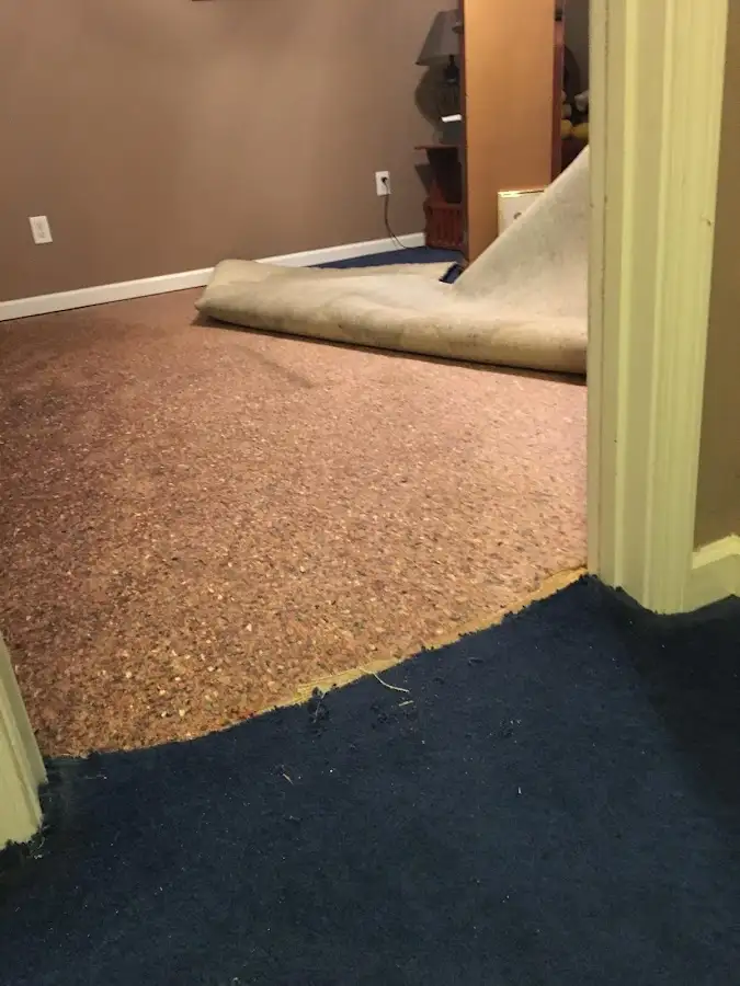 Carpet pad removal revealing water damage during Water Mitigation Services in Lawrenceville